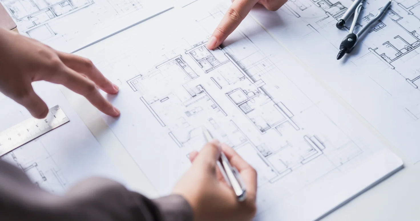 Architect drawing architectural plans on a desk